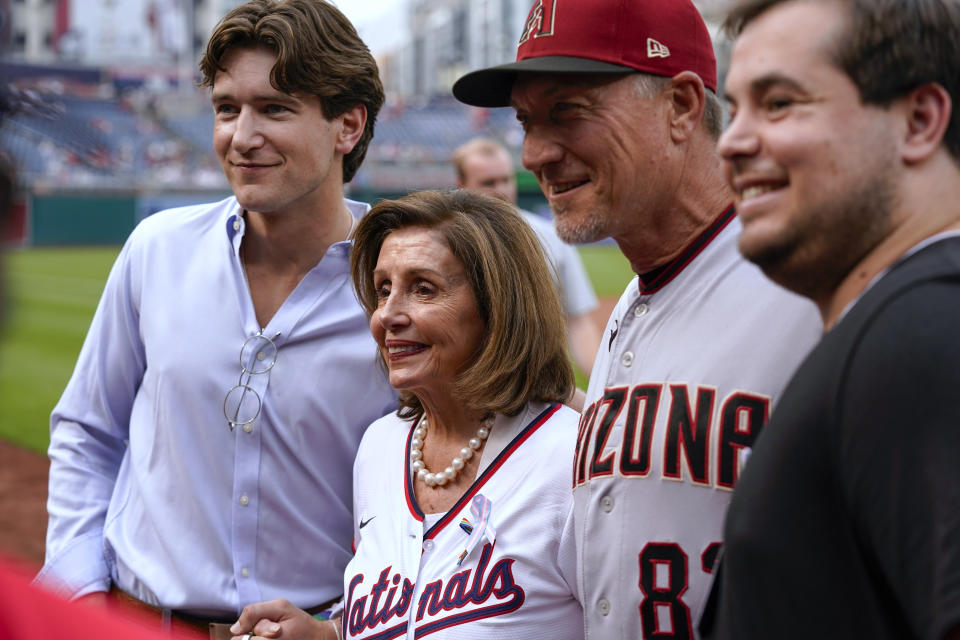 Rep. Nancy Pelosi, D-Calif., second from left, and Arizona Diamondbacks bench coach Jeff Banister, second from right, pose for a photo before she threw out a ceremonial first pitch before a baseball game between the Washington Nationals and the Diamondbacks at Nationals Park, Tuesday, June 6, 2023, in Washington. The Nationals celebrated Pride month with their 18th Night OUT event. (AP Photo/Alex Brandon)