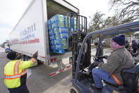 Donated water is unloaded at a distribution site, Thursday, Feb. 18, 2021, in Houston. Houston and several surrounding cities are under a boil water notice as many residents are still without running water in their homes. (AP Photo/David J. Phillip)