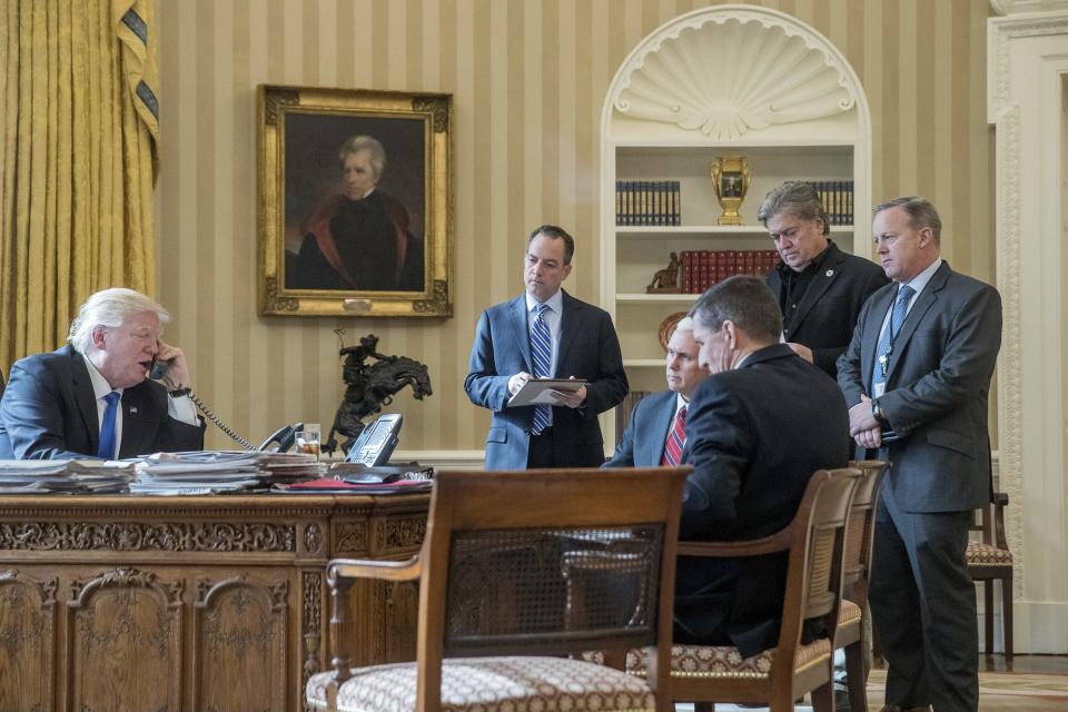 En esta foto de archivo del 28 de enero de 2017, el presidente Donald Trump aparece acompañado por el Jefe de Gabinete Reince Priebus (el segundo de la izquierda), el vicepresidente Mike Pence, el asesor de seguridad nacional Michael Flynn, el asesor principal Steve Bannon y el secretario de prensa de la Casa Blanca Sean Spicer, mientras habla por teléfono con el presidente ruso, Vladimir Putin, en la Oficina Oval de la Casa Blanca en Washington. (Foto de AP / Andrew Harnik)