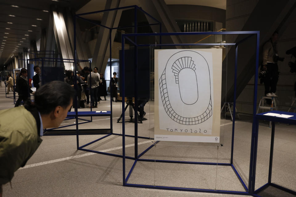 A journalist looks at a poster created by Philippe Weisbecker, one of 20 posters officially selected for the Tokyo Olympics and Paralympics, at the Museum of Contemporary Art Tokyo Monday, Jan. 6, 2020. The official posters are out for this year's Tokyo Olympics and Paralympics. The 20 posters have been created by 19 artists in fields ranging from painting, graphic design, and photography. Calligraphy and Japanese manga are also represented. (AP Photo/Jae C. Hong)