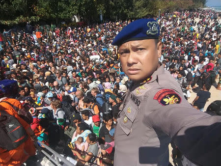 Chief Water Police of Lombok Dewa Wijaya takes a picture in front of hundreds of people attempting to leave the Gili Islands after an earthquake Gili Trawangan, in Lombok, Indonesia, August 6, 2018, in this picture. Indonesia Water Police/Handout/via REUTERS