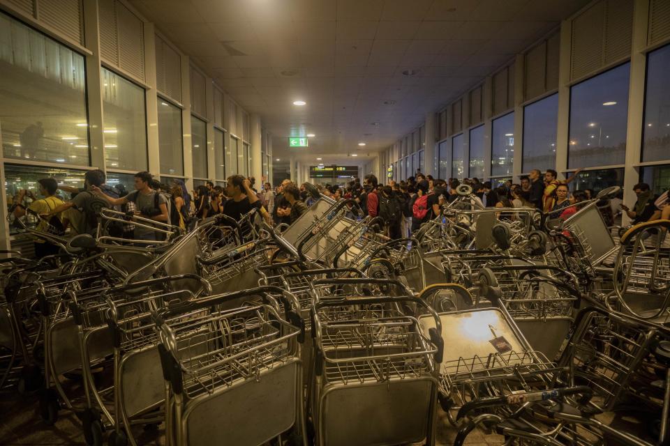 Trolleys block an entrance at El Prat airport, outskirts of Barcelona, Spain, Monday, Oct. 14, 2019. Spain's Supreme Court on Monday sentenced 12 prominent former Catalan politicians and activists to lengthly prison terms for their roles in a 2017 bid to gain Catalonia's independence, sparking protests across the wealthy Spanish region. (AP Photo/Bernat Armangue)