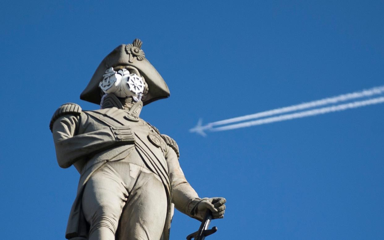 A clean air mask is seen placed on the top of Nelson's Column by Greenpeace activists to protest against air pollution quality in London and cities across the UK - Matt Dunham/AP