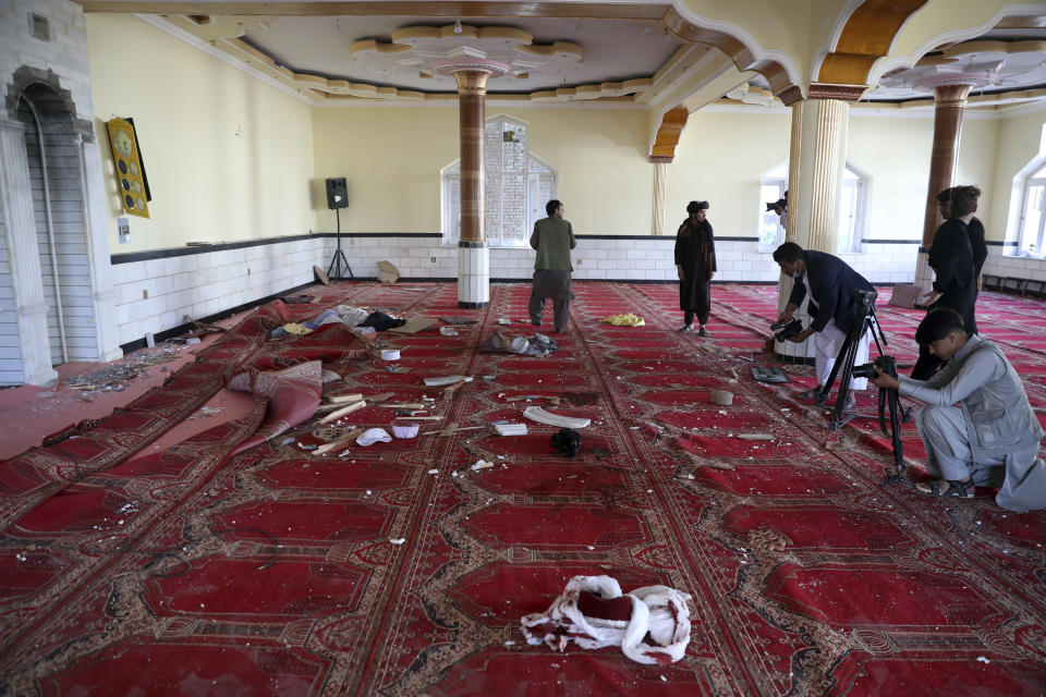 Afghan journalist take photos and film inside a mosque after a bomb explosion in Shakar Dara district of Kabul, Afghanistan, Friday, May 14, 2021. A bomb ripped through a mosque in northern Kabul during Friday prayers killing 12 worshippers, Afghan police said. (AP Photo/Rahmat Gul)