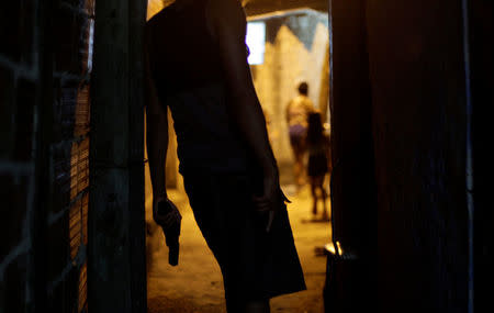 A Brazilian drug gang member poses with a gun in a slum in Rio de Janeiro, Brazil March 13, 2018. Picture taken March 13, 2018. REUTERS/Alan Lima