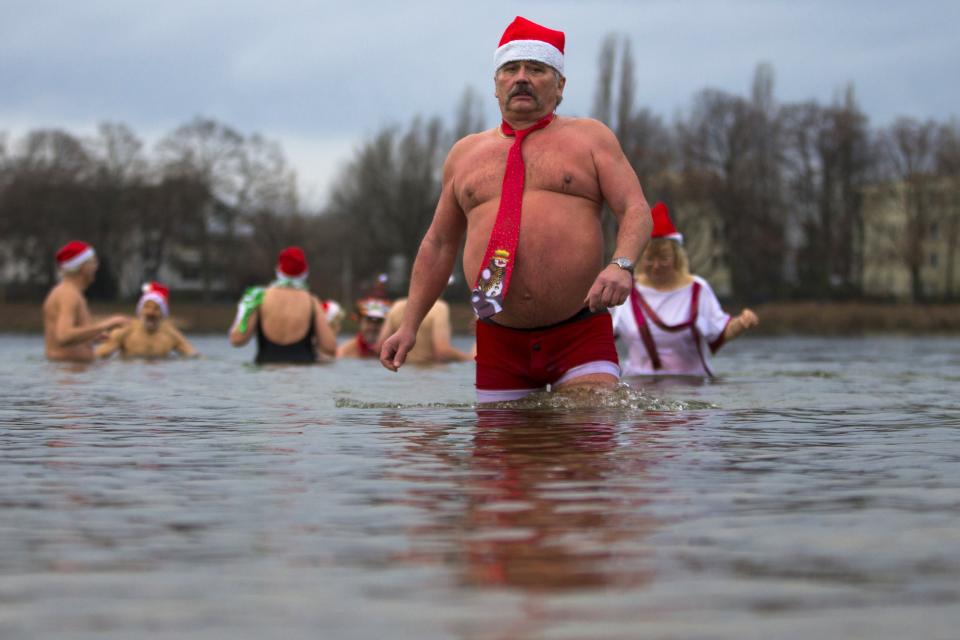 Members of the Berliner Seehunde (Berlin Seals) ice swimmers club take a dip in Lake Orankesee during their traditional Christmas swimming event in Berlin, December 25, 2013. REUTERS/Thomas Peter (GERMANY - Tags: SOCIETY)