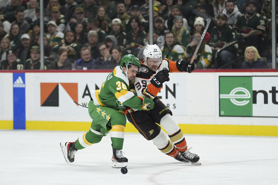 Minnesota Wild right wing Mats Zuccarello, left, and Anaheim Ducks center Sam Carrick (39) battle for the puck during the second period of an NHL hockey game Saturday, Jan. 27, 2024, in St. Paul, Minn. (AP Photo/Abbie Parr)