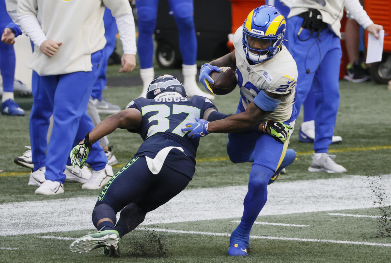 SEATTLE, WASHINGTON - JANUARY 09: Running back Cam Akers #23 of the Los Angeles Rams escapes the tackle of free safety Quandre Diggs #37 of the Seattle Seahawks  during the second quarter of the NFC Wild Card Playoff game at Lumen Field on January 09, 2021 in Seattle, Washington. (Photo by Steph Chambers/Getty Images)