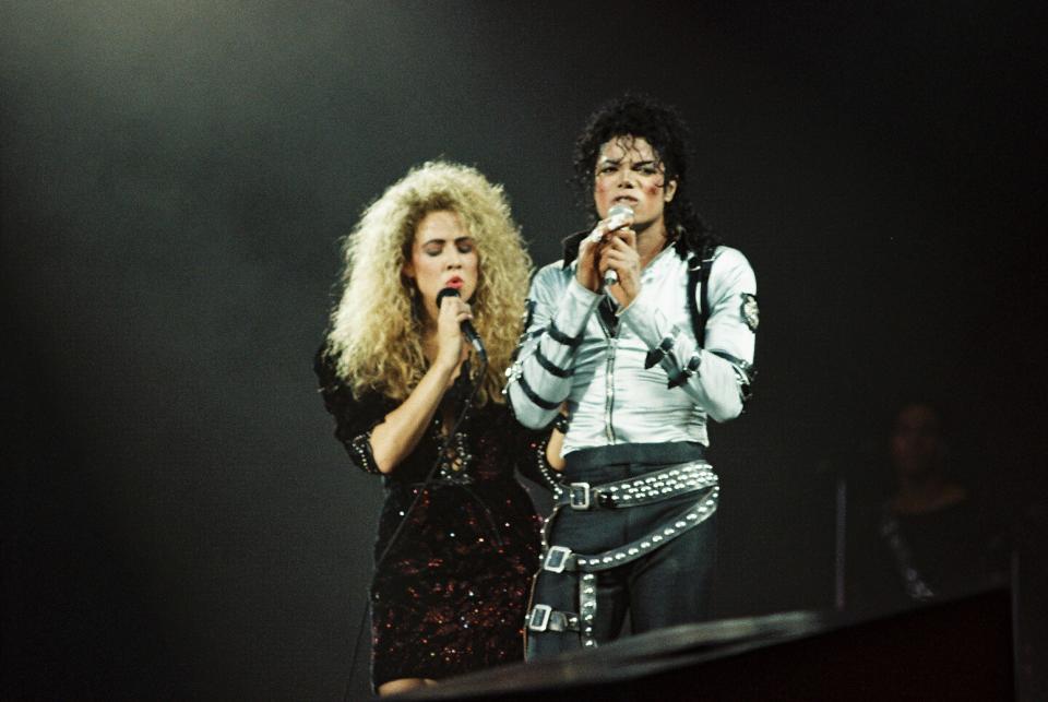 LONDON, UNITED KINGDOM - JULY 23: Sheryl Crow (L) joins Michael Jackson (R) to perform on stage on his BAD tour at Wembley Stadium on 23rd July 1988 in London, United Kingdom. (Photo by Pete Still/Redferns)