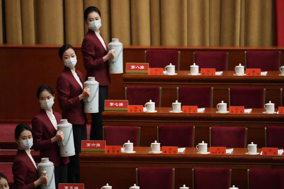 Hostesses prepare drinks at the Great Hall of the People before the opening ceremony for the 20th National Congress of China's ruling Communist Party in Beijing, China, Sunday, Oct. 16, 2022. China on Sunday opens a twice-a-decade party conference at which leader Xi Jinping is expected to receive a third five-year term that breaks with recent precedent and establishes himself as arguably the most powerful Chinese politician since Mao Zedong. (AP Photo/Mark Schiefelbein)