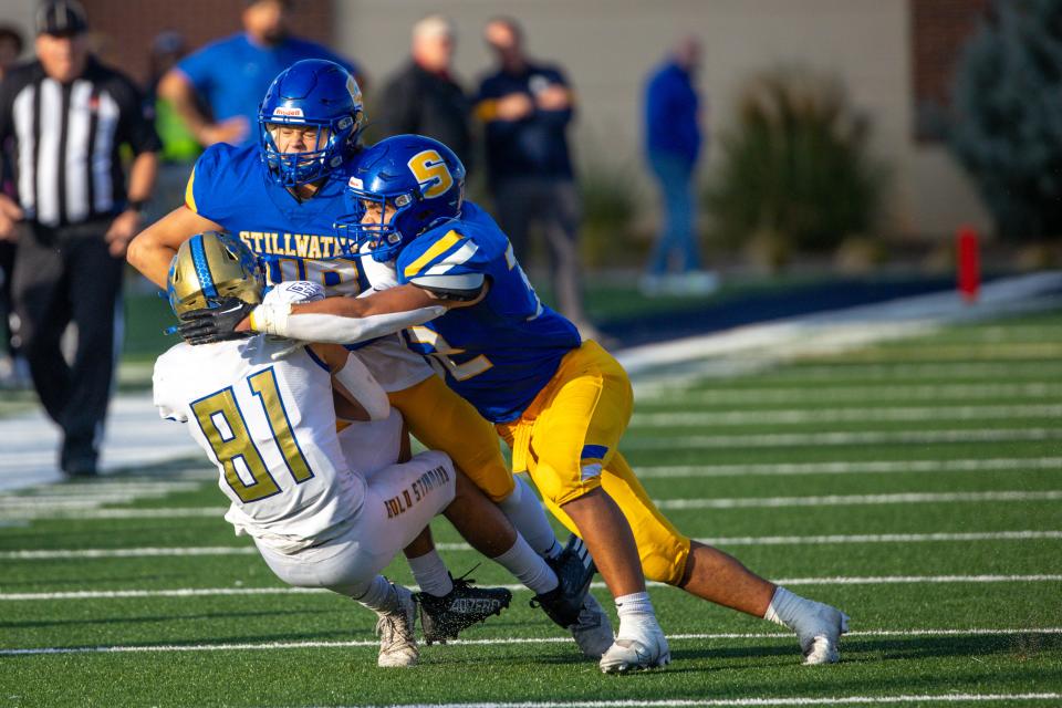 Connor Stover (81) is tackled by Stillwater's Cameron Johnson (32) and Landon Sterling (49) at the 6A-II State Championship football game between Stillwater High School and Choctaw High School played at Chad Richison Stadium at the University of Central Oklahoma in Edmond on Friday, Dec. 2, 2022.