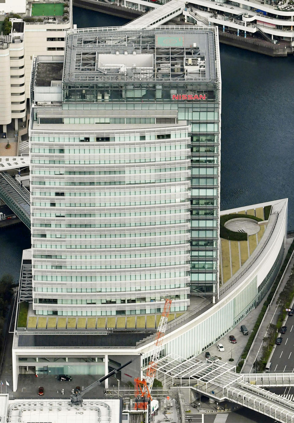 In this aerial photo, Nissan Motor Co. Global Headquarters is seen Tuesday, Nov. 20, 2018 in Yokohama, near Tokyo. Nissan Chairman Carlos Ghosn, who became one of the auto industry's most powerful executives by engineering a turnaround at the Japanese manufacturer, was arrested Monday and will be fired for allegedly underreporting his income and misusing company funds, the automaker said. (Kyodo News via AP)