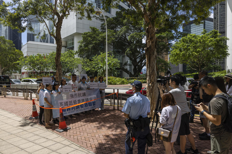 A pro-China group hold a mini protest with a banner reading: "Strong protest against the UK smearing Hong Kong National Security Law" after the British government criticised the arrest warrants issued for 8 pro-democracy activists living in the United States, Britain, Canada and Australia for alleged national security offenses in Hong Kong, Thursday, July 6, 2023. (AP Photo/Louise Delmotte)