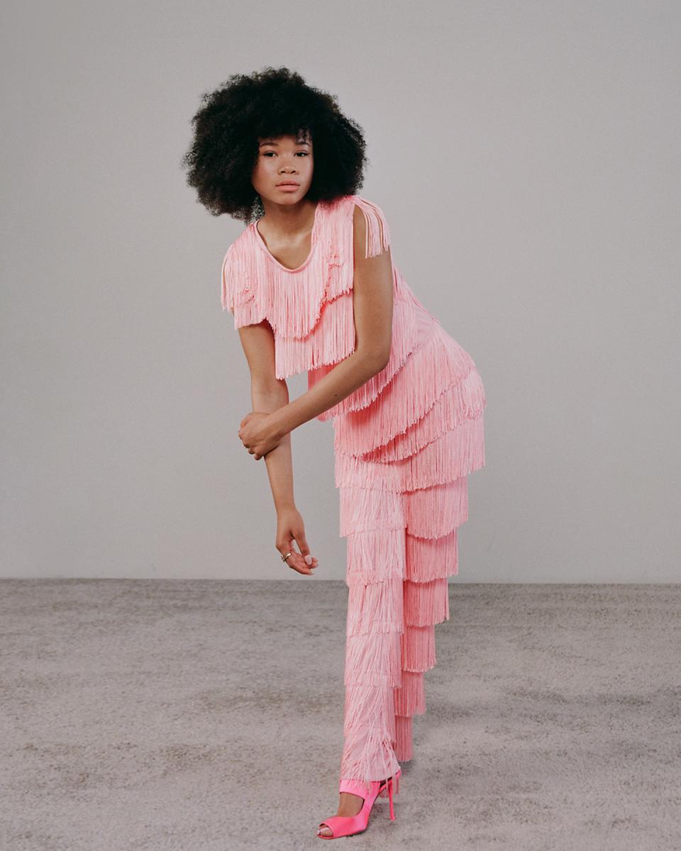Norma Kamali bubble gum pink fringe cropped sleeveless tee, not available for purchase. Norma Kamali bubble gum pink fringe boot pant, $695. Roger Vivier rose button sandal, $1,050.