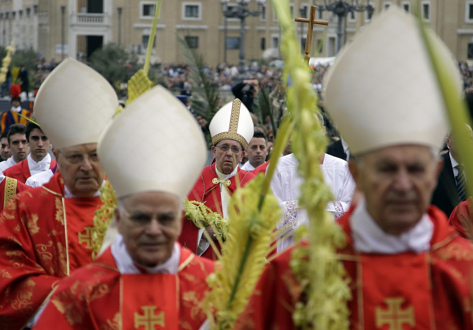 Pope Francis, background center, walks in procession as he celebrates a Palm Sunday mass in St. Peter's Square, at the Vatican, Sunday, April 13, 2014. (AP Photo/Gregorio Borgia)