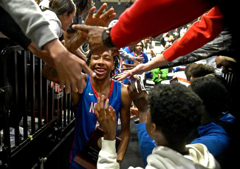 North Meck’s Isaiah Evans, center, is all smiles as fans lean over the railing to congratulate him and the rest of the team following their 65-61 victory in the 4A Regional Championship game on Thursday, March 14, 2024 at Lawrence Joel Veterans Memorial Coliseum in Winston-Salem, NC. North Meck defeated Lake Norman to advance to the NCHSAA final Saturday. JEFF SINER/jsiner@charlotteobserver.com