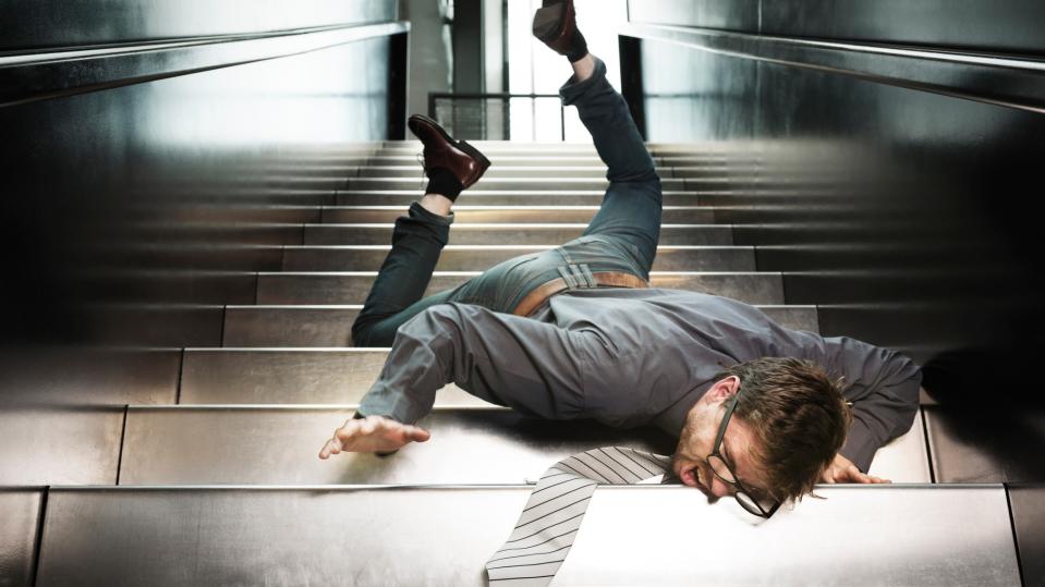 A man in a business suit falling down the stairs.