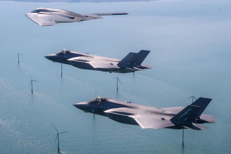 A United States Air Force B2 Spiri flies above the English countryside near Dover with two RAF F-35 jets (MOD)