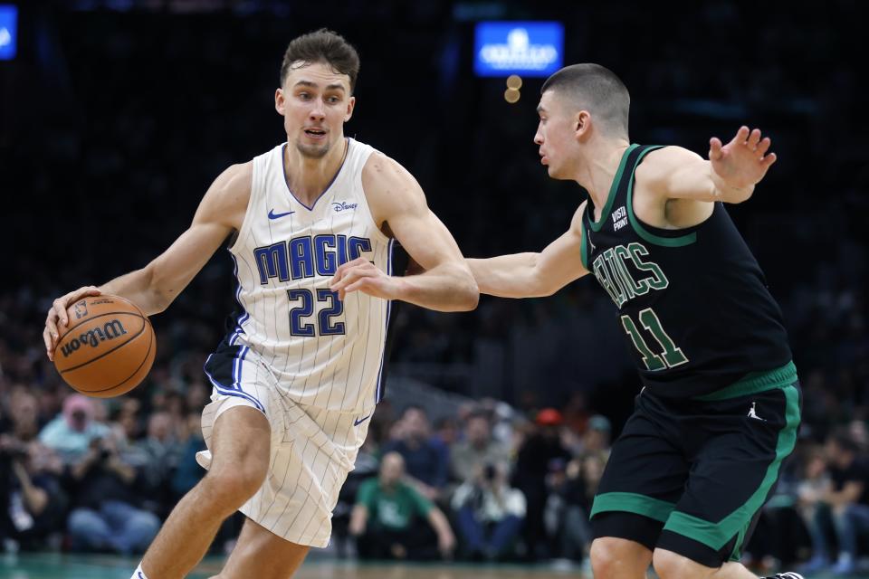 Orlando Magic's Franz Wagner (22) drives past Boston Celtics' Payton Pritchard (11) during the second half of an NBA basketball game Friday, Dec. 15, 2023, in Boston. (AP Photo/Michael Dwyer)