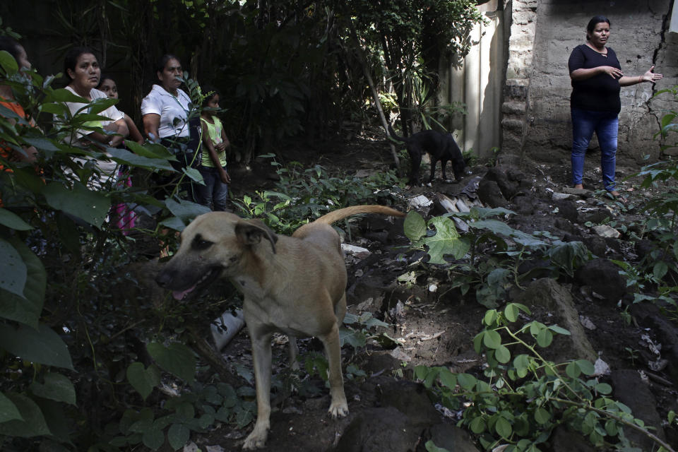 Mudslide survivor Cecilia Flores stands next to her home in Los Angelitos, El Salvador, Wednesday, July 28, 2021. The house has been seriously damaged by government when it cleared land after the October 2020 landslide. (AP Photo/Salvador Melendez)