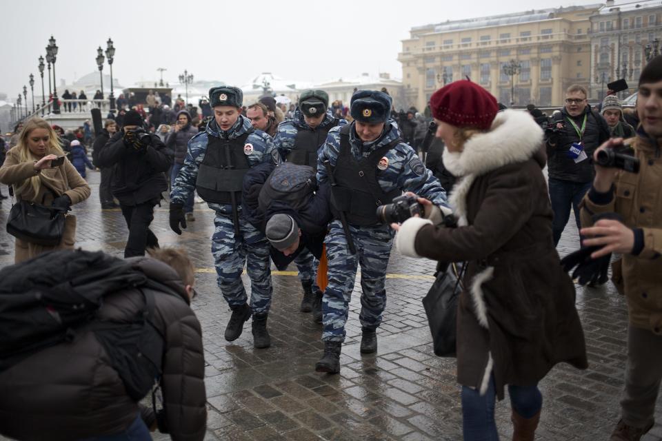 FILE - In this Saturday, Feb. 8, 2014 file photo, police officers detain a protester near Red Square during an unauthorized protest in Moscow, Russia. Around 40 people gathered in downtown Moscow to protest the decision of leading Russian cable and satellite companies to drop the channel, Dozhd (TV Rain). The independent television station Dozhd, or TV Rain, came under attack after asking viewers in January whether the Soviet Union should have surrendered Leningrad, now St. Petersburg, to save the lives of the 1 million people who died during the nearly 900-day Nazi siege of the city during the war. The station quickly pulled the poll and apologized, but President Vladimir Putin’s spokesman said the station had crossed a “red line.” Russian cable operators lined up to drop Dozhd from their packages and prosecutors opened an investigation. (AP Photo/Alexander Zemlianichenko, file)