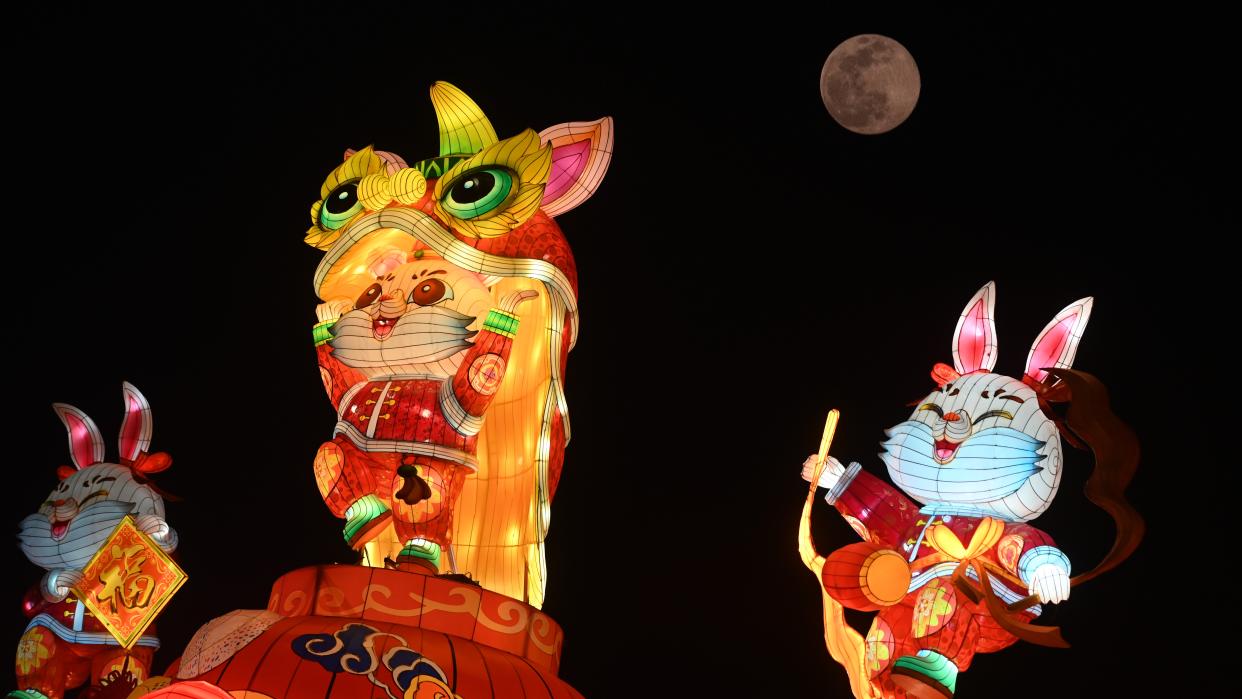  three colorful rabbit characters in front of full moon in background 