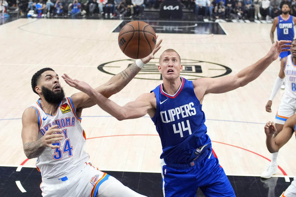 Oklahoma City Thunder forward Kenrich Williams, left, and Los Angeles Clippers center Mason Plumlee reach for a rebound during the first half of an NBA basketball game Tuesday, Jan. 16, 2024, in Los Angeles. (AP Photo/Mark J. Terrill)