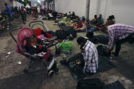 Migrants start waking up on the street in Huixtla, Chiapas state, Mexico, at daybreak Tuesday, Oct. 26, 2021, as they use the day to rest during their trek by foot toward the U.S. (AP Photo/Marco Ugarte)