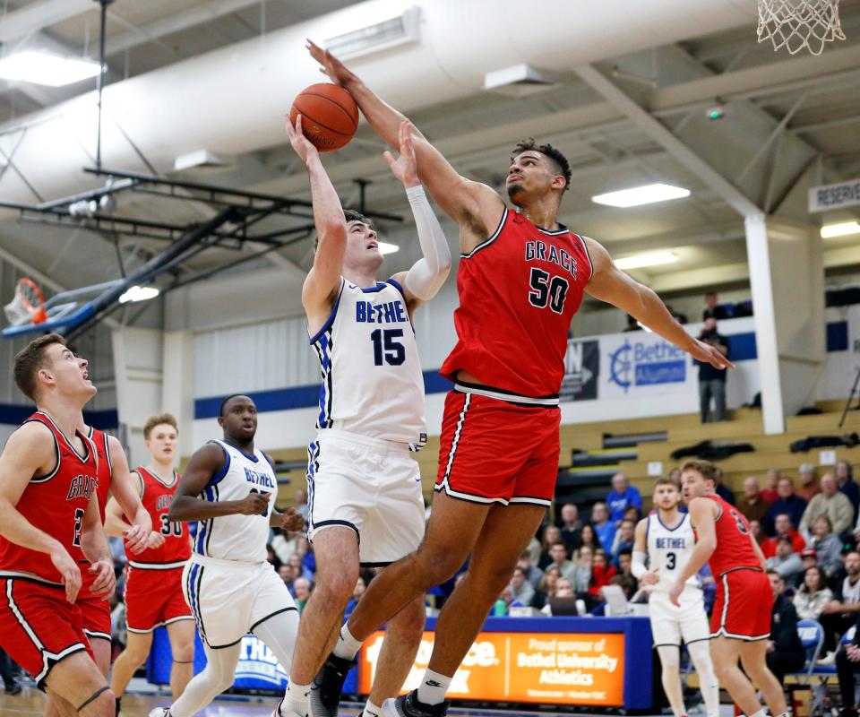 Grace College senior Elijah Malone (50) blocks the shot of Bethel senior Nathan Aerts during a men's basketball game Wednesday, Jan. 24, 2024, at Bethel University in Mishawaka.