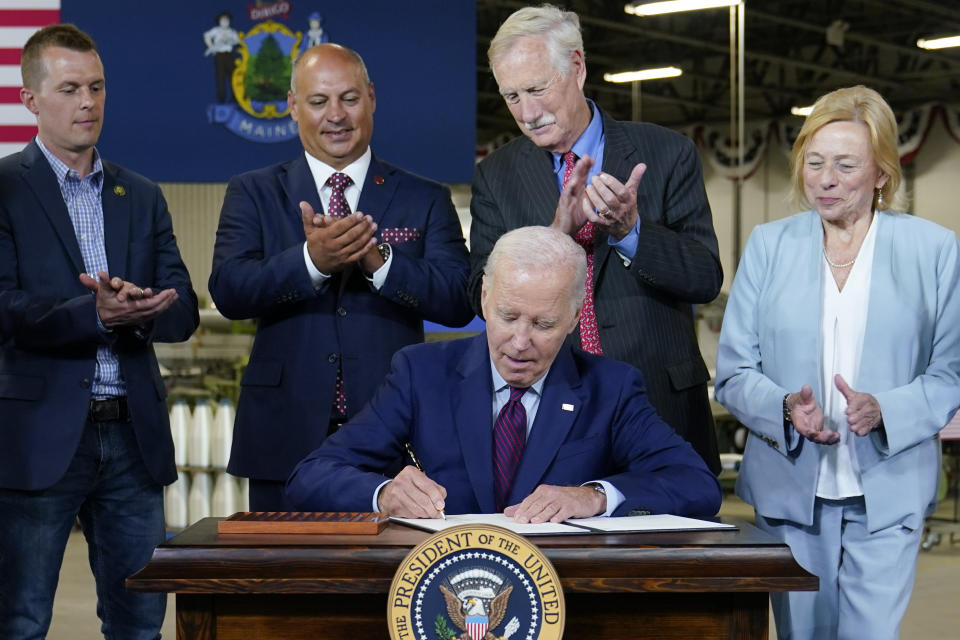 President Joe Biden signs an executive order to encourage companies to manufacture new inventions in the United States at Auburn Manufacturing Inc., in Auburn, Maine, Friday, July 28, 2023. Back row from left, Rep. Jared Golden, D-Maine, Auburn, Maine Mayor Jason Levesque, Sen. Angus King, I-Maine, and Maine Gov. Janet Mills. (AP Photo/Susan Walsh)