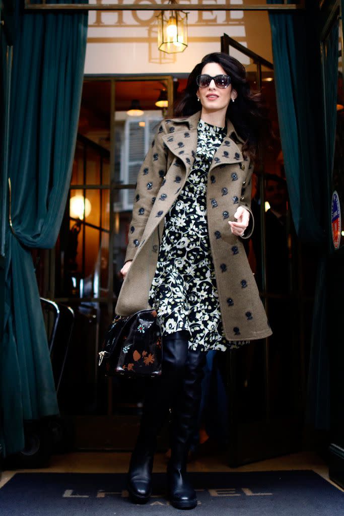 <p>Amal steps out in Paris wearing a printed dress with an embellished wool coat. She accessorizes the outfit with over-the-knee-boots and oversized sunglasses.</p>