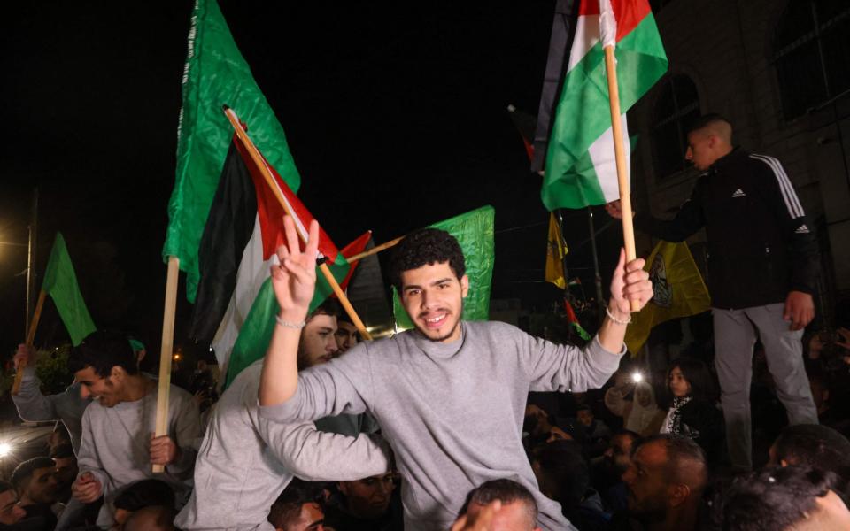 Palestinian prisoners (wearing grey jumpers) cheer after being released from the Israeli Ofer military facility in Baytunia in the occupied West Bank in exchange for hostages freed by Hamas in Gaza, on November 24, 2023. After 48 days of gunfire and bombardment that claimed thousands of lives, the first hostages to be released under a truce deal between Israel and Hamas were handed over on November 24, both sides said, nearly seven weeks after they were seized. (Photo by AHMAD GHARABLI / AFP) (Photo by AHMAD GHARABLI/AFP via Getty Images)