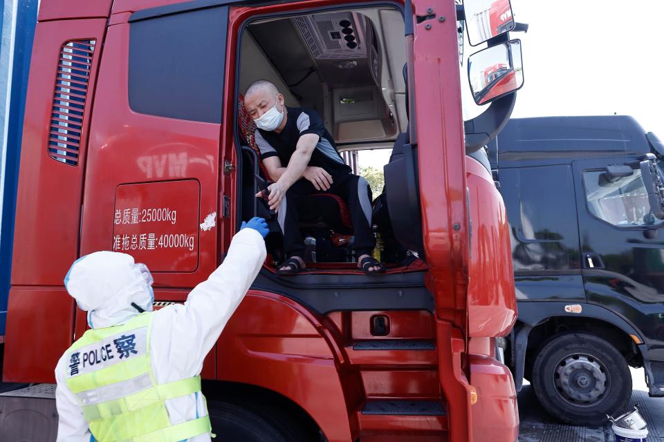 A truck driver presents a negative Covid-19 test to a a traffic police officer in Shanghai in April 2022.