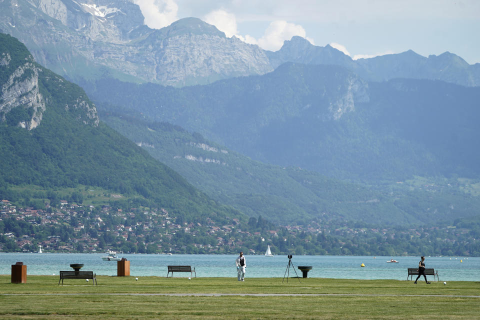 Police officers work near the scene after a knife attack Thursday, June 8, 2023 in Annecy, French Alps. A man with a knife stabbed several very young children, including at least one in a stroller, and also assaulted adults in a lakeside park in the French Alps. The savagery left at least two children and one adult with life-threatening injuries, authorities said. (AP Photo/Laurent Cipriani)