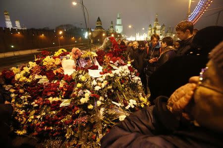 People gather at the site where Boris Nemtsov was recently murdered, with St. Basil's Cathedral and the Kremlin walls seen in the background, in central Moscow, February 28, 2015. REUTERS/Maxim Zmeyev