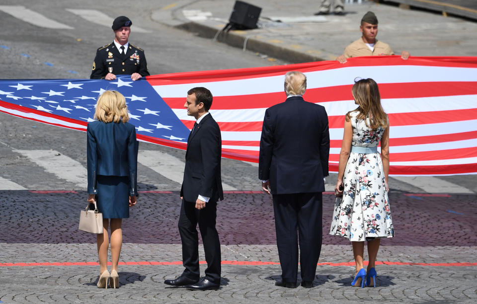 <p>(From right) First Lady Melania Trump, President Donald Trump, French President Emmanuel Macron and his wife Brigitte Macron, stand in front of the U.S. national flag held by soldiers, at the end of the annual Bastille Day military parade on the Champs-Elysees avenue in Paris on July 14, 2017. (Photo: Alain Jocard/AFP/Getty Images) </p>