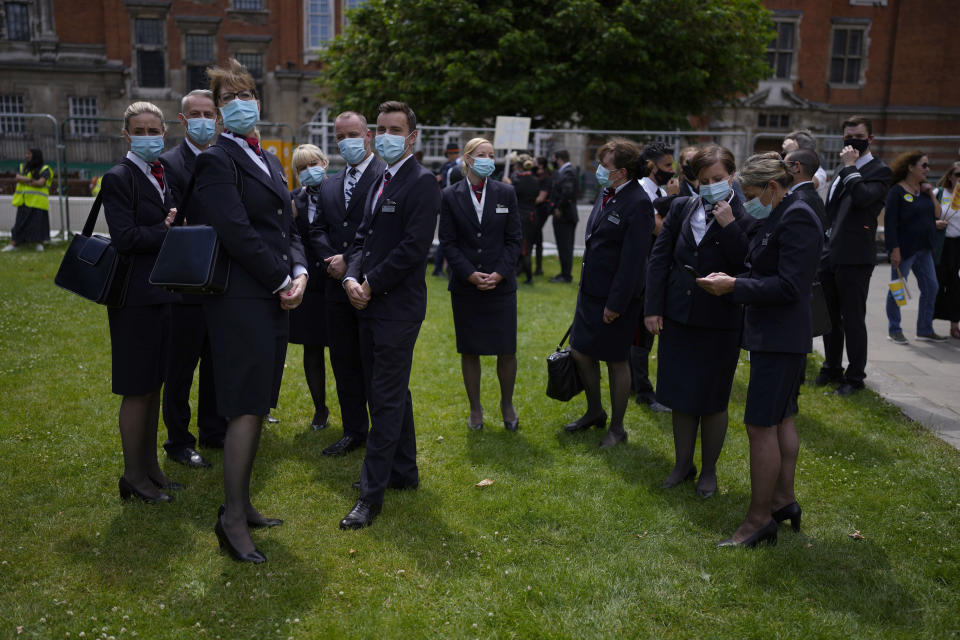 British Airways cabin crew take part in a 'Travel Day of Action' protest across the street from the Houses of Parliament in London, Wednesday, June 23, 2021. The protest on Wednesday was attended by people from across the UK aviation and travel industry calling on the British government to safely reopen international travel for the peak summer season to protect travel jobs and businesses amidst Britain's widely praised rollout of coronavirus vaccines. (AP Photo/Matt Dunham)