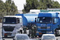 Soldiers get ready two tanker trucks at a fuel depot in Aveiras, outside Lisbon, Tuesday, Aug. 13, 2019. Soldiers are driving tanker trucks to distribute gas in Portugal as an open-ended truckers' strike over pay enters its second day. The government has issued an order allowing the army to be used. (AP Photo/Armando Franca)