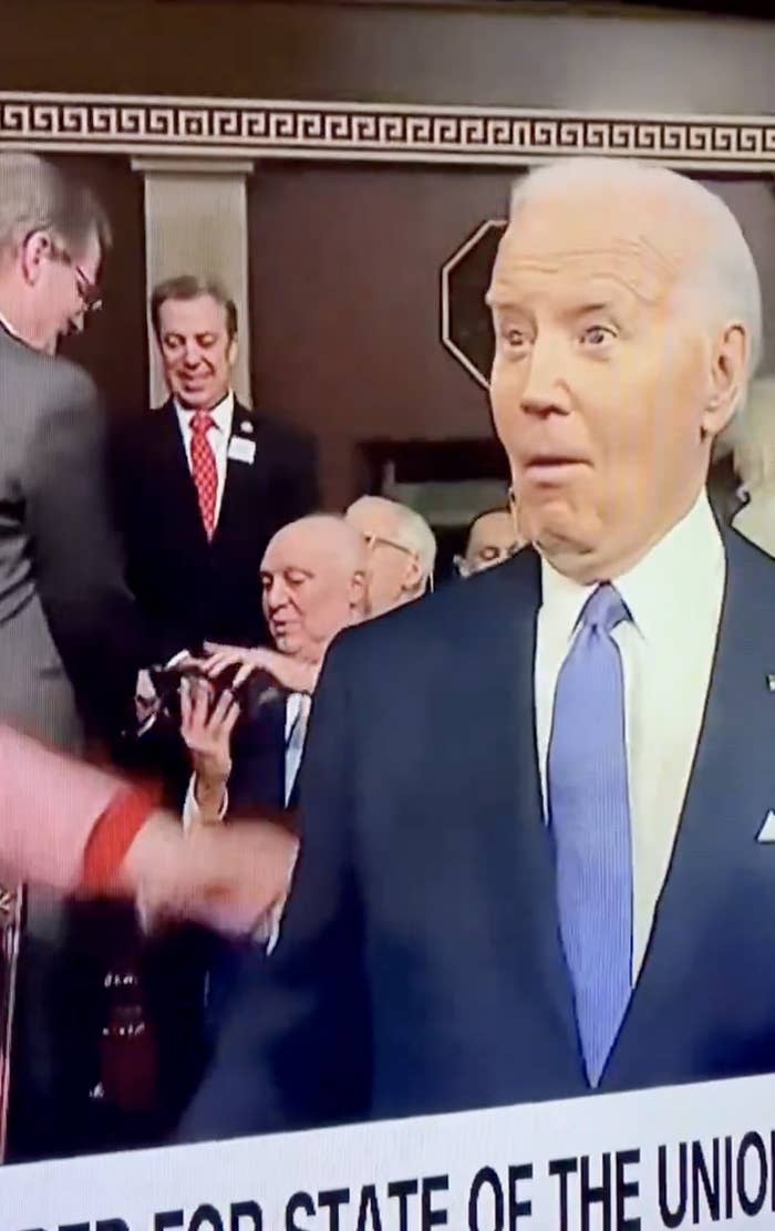 President in blue suit pre-State of the Union address; attendees in background