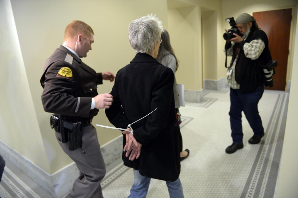 Gail Murdock, center, is arrested after blocking the doors to a committee meeting room at the Utah Capitol in Salt Lake City on Monday, Feb. 10, 2014. Utah Highway Patrol troopers, which provide Capitol security, led the protesters out in three waves after they blocked Senator Stuart Reid, R-Ogden, and visitors from two sets of double doors to the room. Protesters are calling for a statewide anti-discrimination law that includes sexual and gender orientation protections. (AP Photo/The Salt Lake Tribune, Francisco Kjolseth)