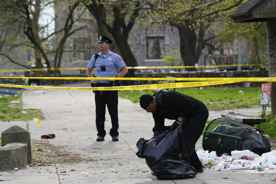 A person picks up debris in the aftermath of a shooting at an Eid event in Philadelphia, Wednesday, April 10, 2024. (AP Photo/Matt Rourke)