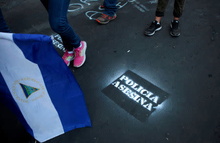 FILE PHOTO: Demonstrators walk past graffiti reading "Murderous Police" during protest against Nicaraguan President Daniel Ortega's government in Managua, Nicaragua May 15, 2018. REUTERS/Oswaldo Rivas/File Photo