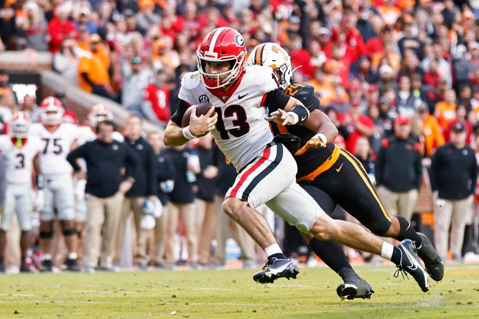 Georgia quarterback Stetson Bennett (13) runs for a touchdown as he's chased by Tennessee linebacker Aaron Beasley during the first half at Neyland Stadium.