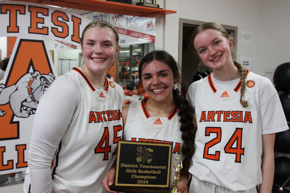 Lorin Wagner (left), Kymber Beltran (center) and Abby Hauschild pose with the District 4-4A postseason championship trophy on March 1, 2024.