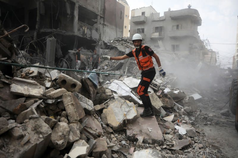 Palestinians inspect the destruction following Israeli airstrikes on a market in residential neighborhood in Khan Younis, southern Gaza Strip on Tuesday. Photo by Ismael Mohamad/UPI