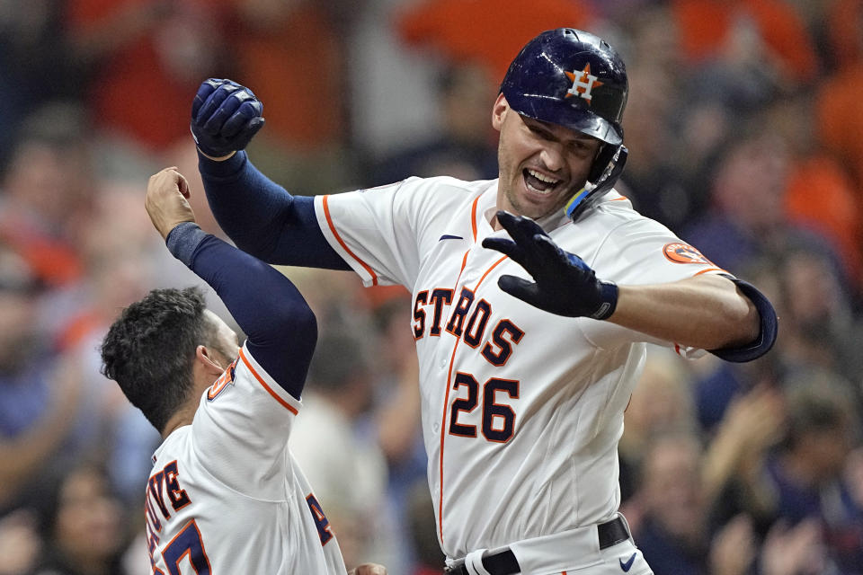 FILE - Houston Astros' Trey Mancini (26) celebrates with Jose Altuve after hitting a two-run home run against the Minnesota Twins during the sixth inning of a baseball game Wednesday, Aug. 24, 2022, in Houston. When Chicago Cubs manager David Ross spoke with Trey Mancini about joining the team, the skipper mentioned playing first base, designated hitter and the corner outfield spots. “I told him ‘I don’t care where I play at all. I like playing. Wherever you want me, I'm there,'” Mancini said Monday, Jan. 23, 2023. (AP Photo/David J. Phillip, File)