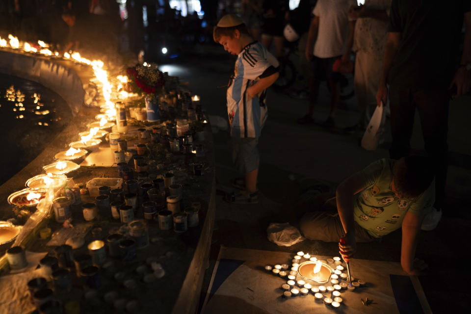 A boy lights candles in the form of the Star of David in honour of victims of the Hamas attacks during a vigil at the Dizengoff square in central Tel Aviv, Israel, on Wednesday, Oct 18, 2023.(AP Photo/Petros Giannakouris)