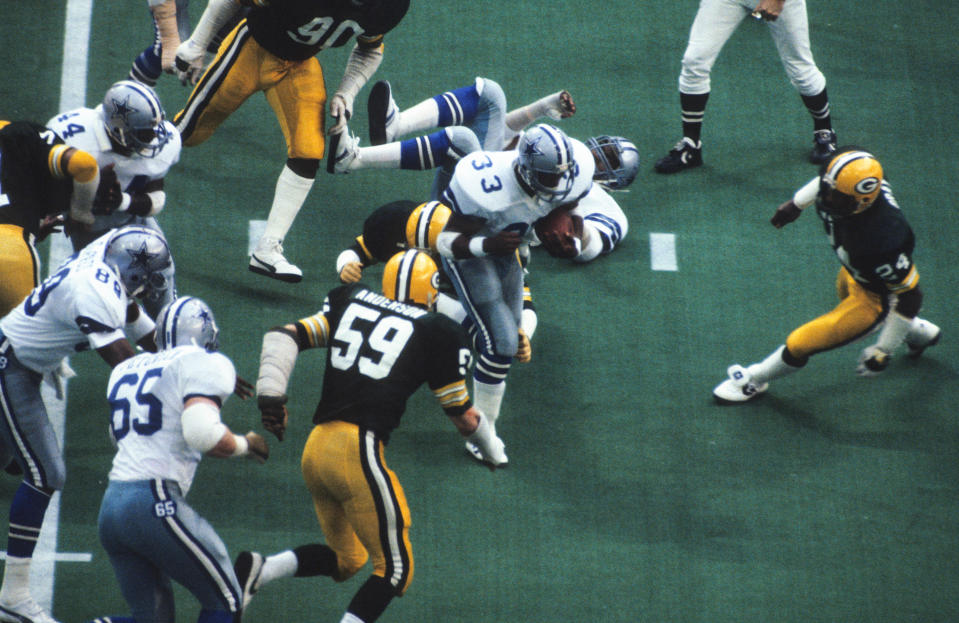 Dallas Cowboys running back Tony Dorsett (33) runs the ball as the Green Bay Packers' John Anderson (59) and Johnnie Gray (24) pursue during the 1982 NFC divisional playoff game at Texas Stadium.