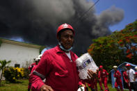 Members of the Cuban Red Cross prepare to be transported to the Matanzas Supertanker Base, where firefighters work to quell a blaze which began during a thunderstorm the night before, in Matazanas, Cuba, Saturday, Aug. 6, 2022. The fire at an oil storage facility raged uncontrolled Saturday, where four explosions and flames injured nearly 80 people and left over a dozen firefighters missing, Cuban authorities said. (AP Photo/Ramon Espinosa)