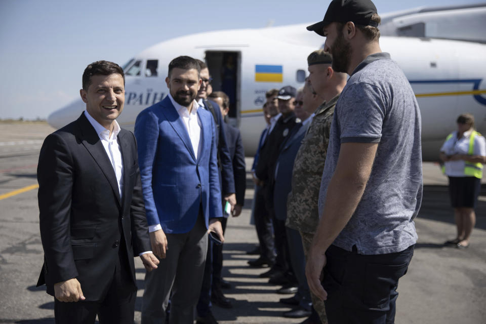 Ukrainian President Volodymyr Zelenskiy, left, smiles as he speaks to local officials upon his arrival to the Zaporizhye region, Ukraine, Thursday, July 18, 2019. Zelenskiy's party is showing the most support in opinion polls ahead of Sunday's snap parliamentary elections, but obtaining a solid majority in the Verkhovna Rada is far from certain. (Ukrainian Presidential Press Office via AP)